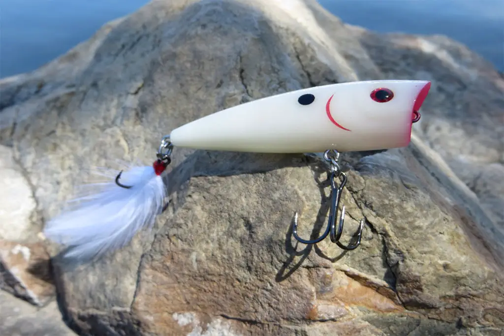 popper lures sitting on a rock at Utah Lake