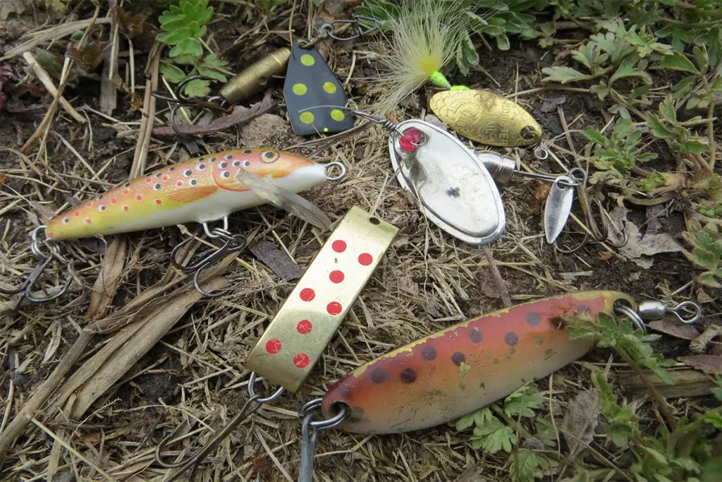 trout lures sitting on the bank by a river