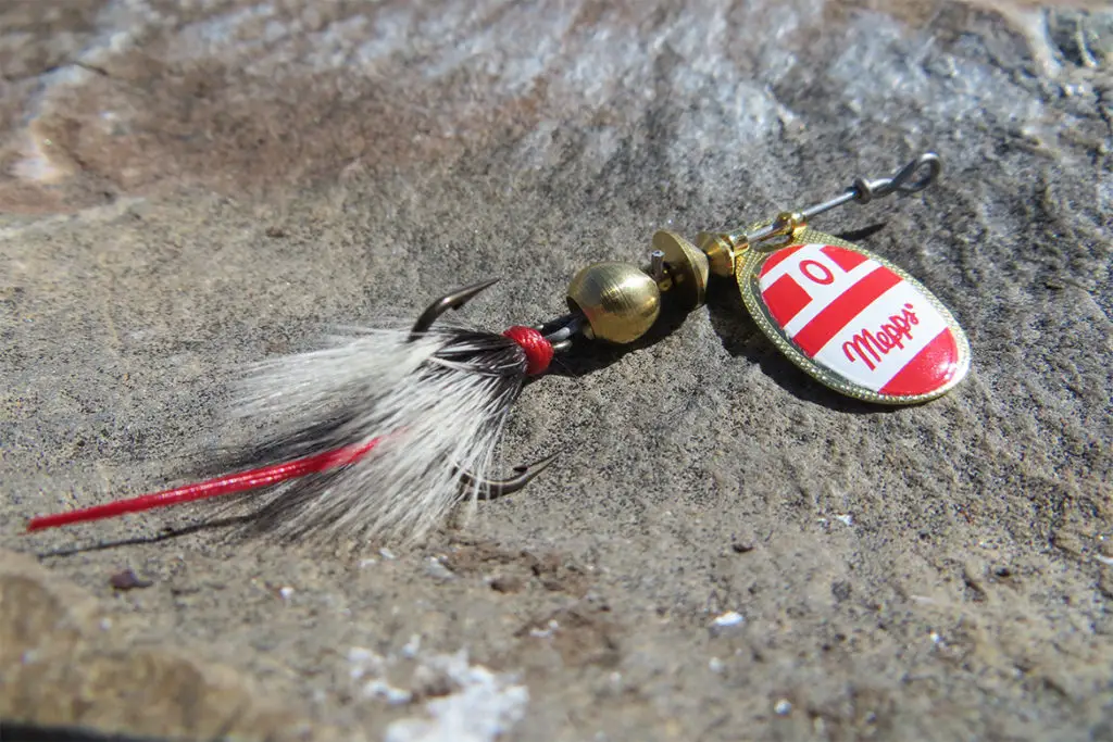 meps red and gold spinner sitting on a rock by a steam