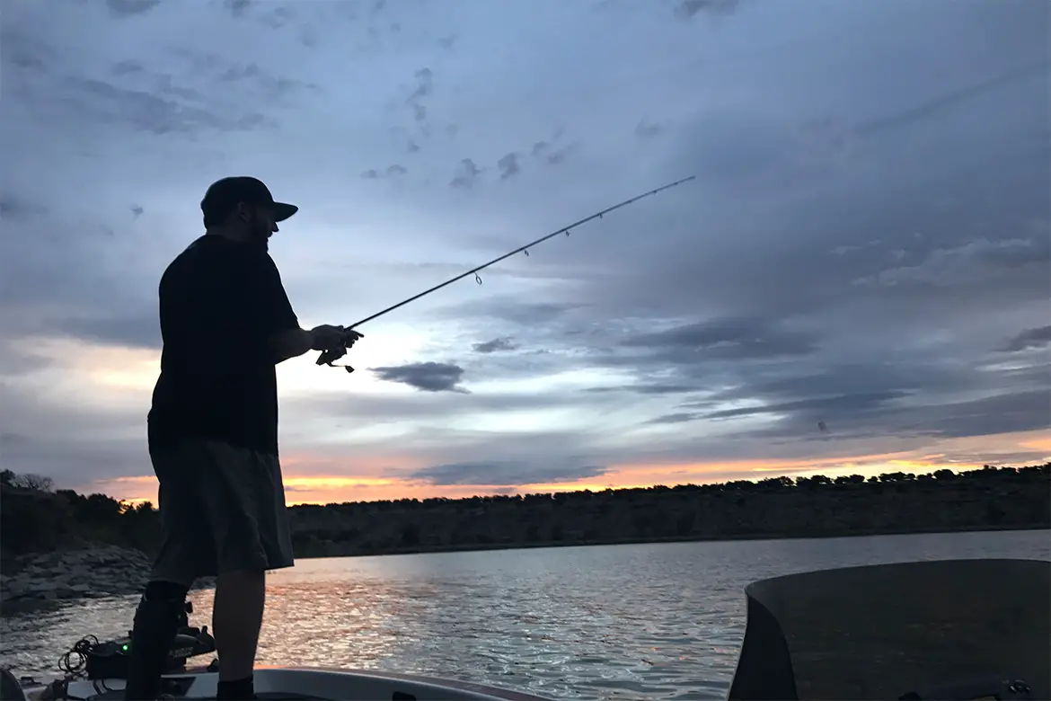 Fishermen on a boat night fishing with topwater lures